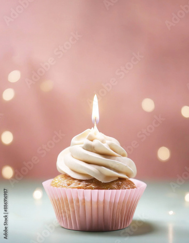 Birthday cupcake with a single candle on pink background with copy space