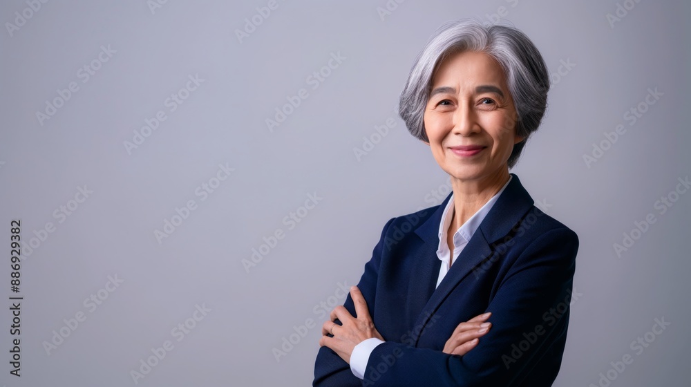 Confident Elderly Indonesian Businesswoman with Grey Hair in Blue Suit, Professional Portrait for Corporate Use Confident Elderly Indonesian Businesswoman with Grey Hair in Blue Suit, Professional Portrait for Corporate Use