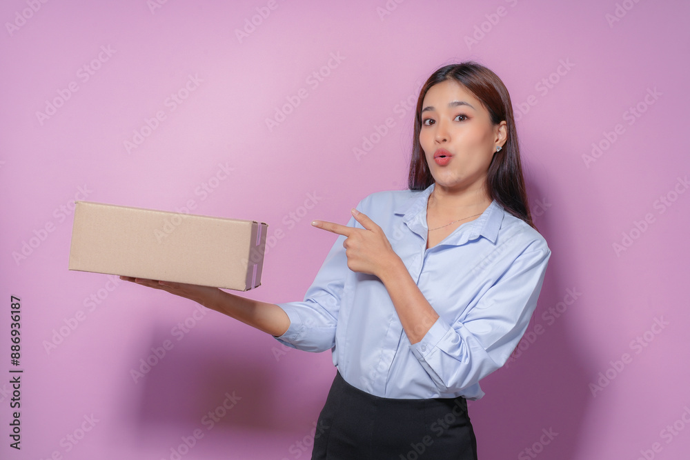 Excited young woman unboxes package against pink background, showcasing small business with happy expression. Online shopping joy captured in studio shot Excited young woman unboxes package against pink background, showcasing small business with happy expression. Online shopping joy captured in studio shot