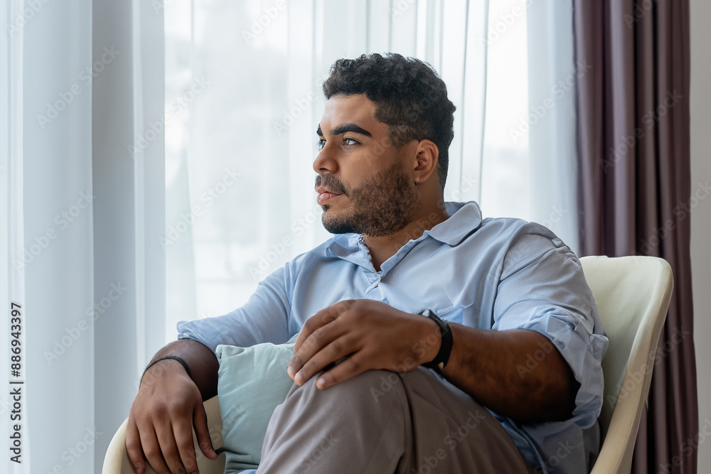 Man reflects on his life with thoughtfulness. happy young relax concept. man in a chair looking out of a window. a man in a chair looking out to the window reflecting his thoughtful lifestyle life. Man reflects on his life with thoughtfulness. happy young relax concept. man in a chair looking out of a window. a man in a chair looking out to the window reflecting his thoughtful lifestyle life.