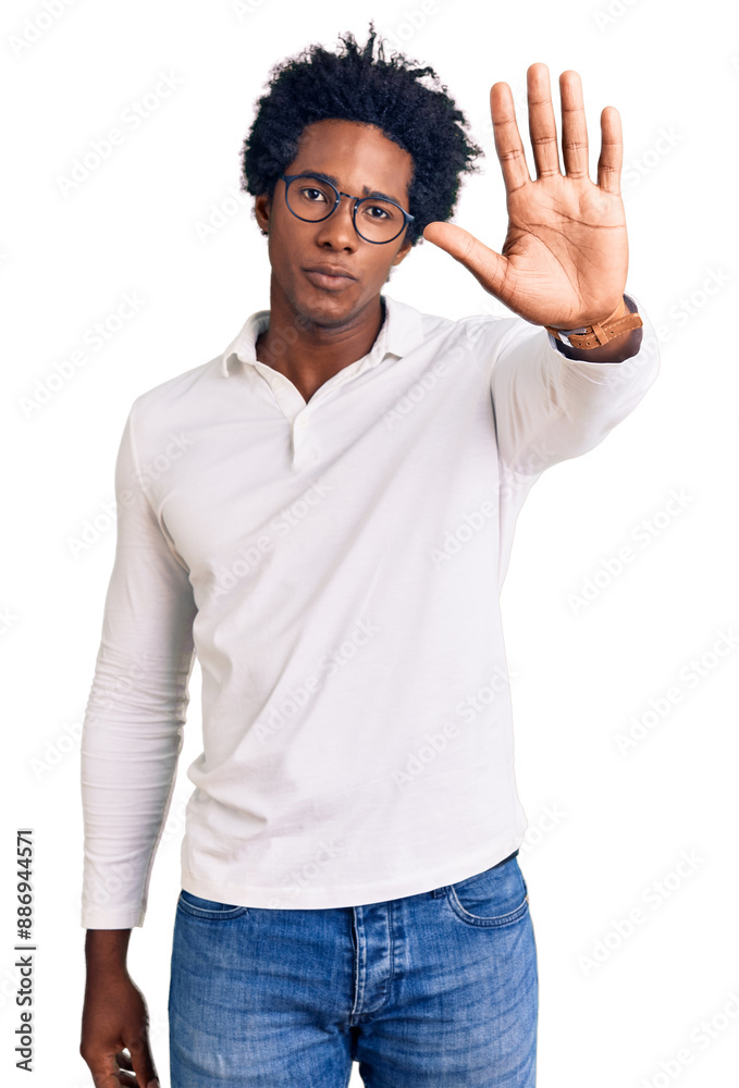 Handsome african american man with afro hair wearing casual clothes and glasses doing stop sing with palm of the hand. warning expression with negative and serious gesture on the face. Handsome african american man with afro hair wearing casual clothes and glasses doing stop sing with palm of the hand. warning expression with negative and serious gesture on the face.