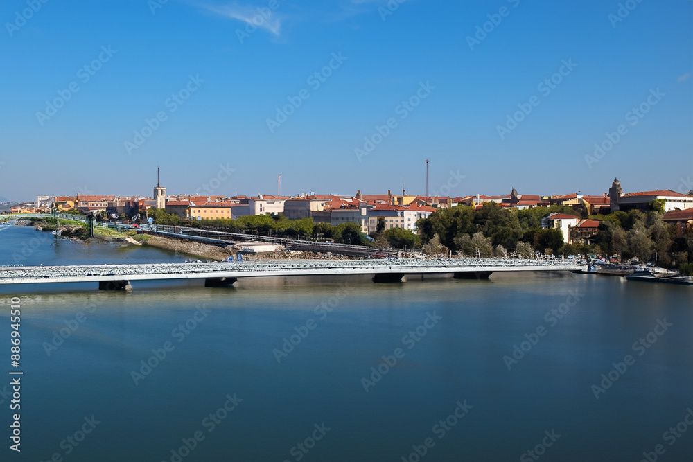 Obraz premium Movement of people and communication between cities. Travel landscape concept. A city stands on water under bridge. A bridge stands in water between lifestyle cities to facilitate communication 