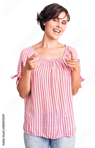 Beautiful young woman with short hair wearing casual summer clothes pointing fingers to camera with happy and funny face. good energy and vibes.
