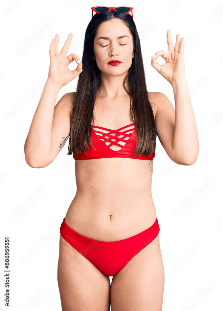 Young beautiful caucasian woman wearing bikini relax and smiling with eyes closed doing meditation gesture with fingers. yoga concept. Young beautiful caucasian woman wearing bikini relax and smiling with eyes closed doing meditation gesture with fingers. yoga concept.
