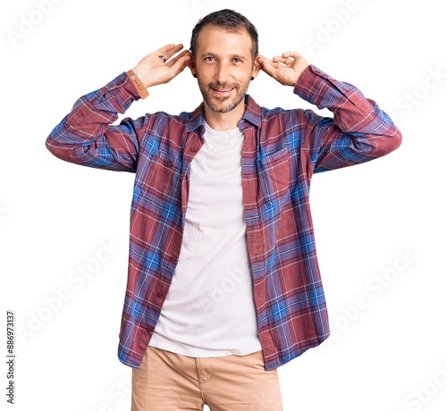 Young handsome man wearing casual clothes smiling pulling ears with fingers, funny gesture. audition problem