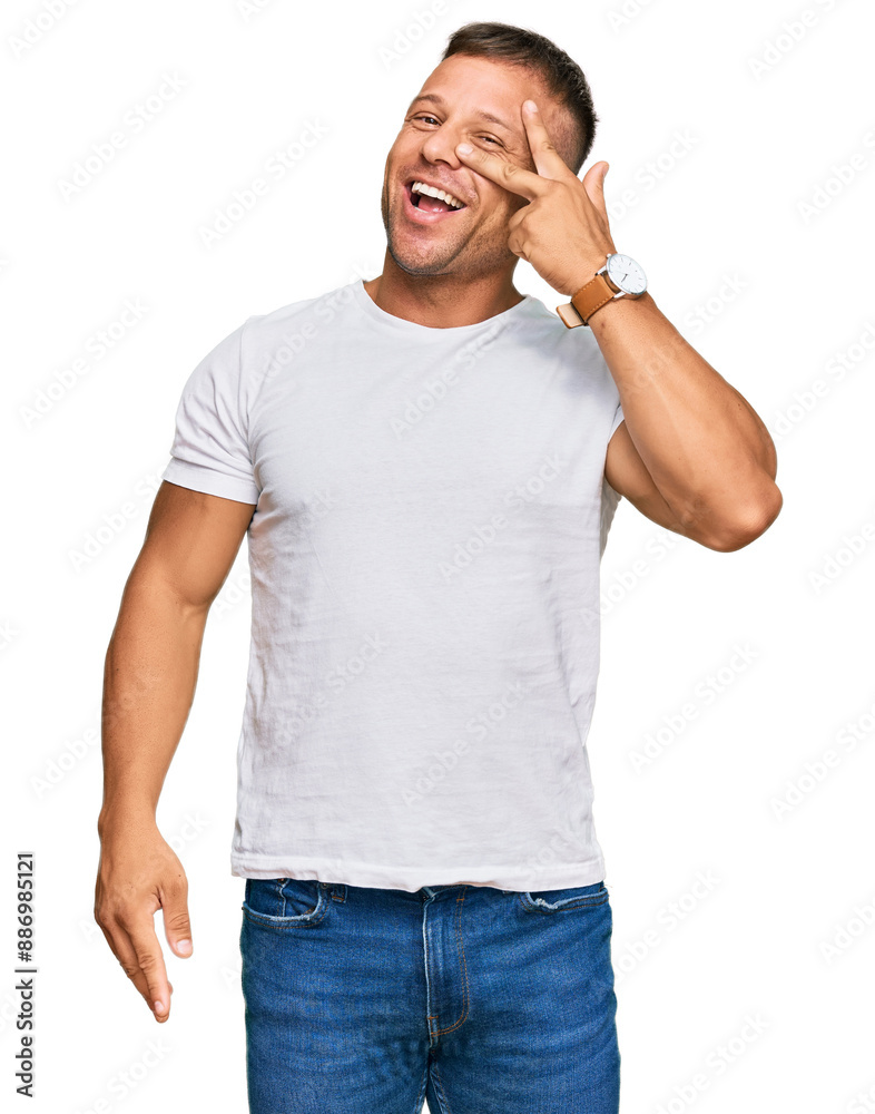 Handsome muscle man wearing casual white tshirt doing peace symbol with fingers over face, smiling cheerful showing victory Handsome muscle man wearing casual white tshirt doing peace symbol with fingers over face, smiling cheerful showing victory