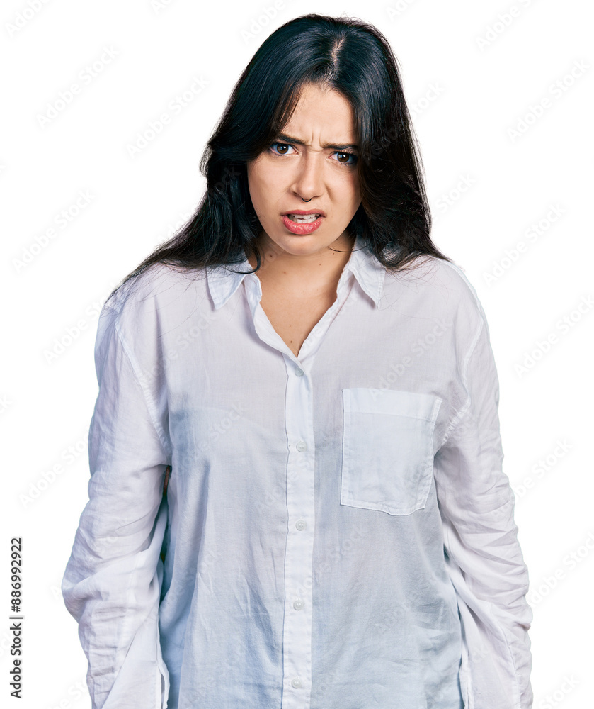 Beautiful hispanic woman wearing casual white shirt skeptic and nervous, frowning upset because of problem. negative person. Beautiful hispanic woman wearing casual white shirt skeptic and nervous, frowning upset because of problem. negative person.