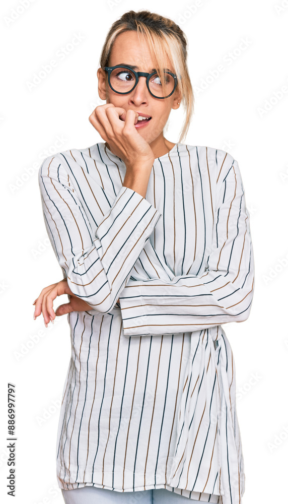 Beautiful blonde woman wearing business shirt and glasses looking stressed and nervous with hands on mouth biting nails. anxiety problem. Beautiful blonde woman wearing business shirt and glasses looking stressed and nervous with hands on mouth biting nails. anxiety problem.