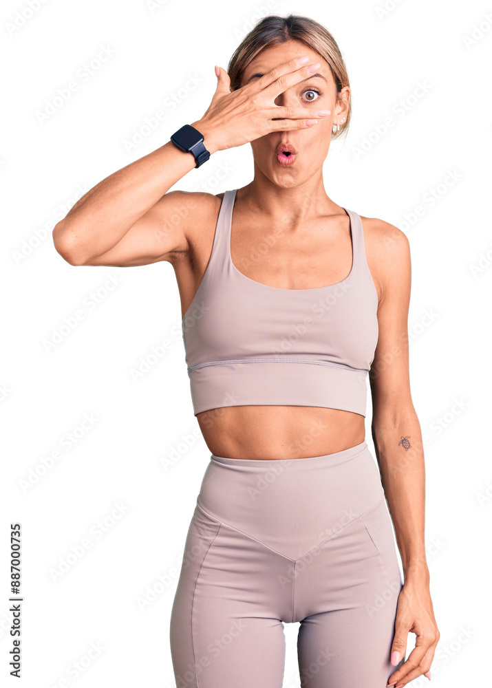 Beautiful caucasian woman wearing sportswear peeking in shock covering face and eyes with hand, looking through fingers with embarrassed expression. Beautiful caucasian woman wearing sportswear peeking in shock covering face and eyes with hand, looking through fingers with embarrassed expression.