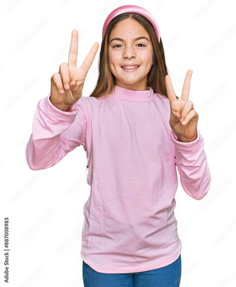 Beautiful brunette little girl wearing casual turtleneck sweater smiling looking to the camera showing fingers doing victory sign. number two. Beautiful brunette little girl wearing casual turtleneck sweater smiling looking to the camera showing fingers doing victory sign. number two.