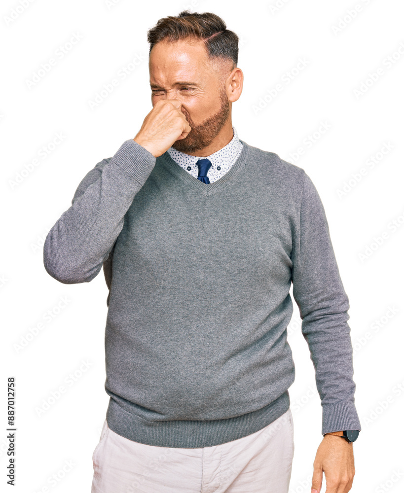 Handsome middle age man wearing business clothes smelling something stinky and disgusting, intolerable smell, holding breath with fingers on nose. bad smell Handsome middle age man wearing business clothes smelling something stinky and disgusting, intolerable smell, holding breath with fingers on nose. bad smell