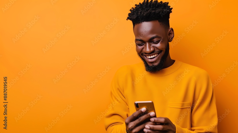a young guy with a smartphone in his hands smiling, wearing yellow clothes on a yellow background a young guy with a smartphone in his hands smiling, wearing yellow clothes on a yellow background