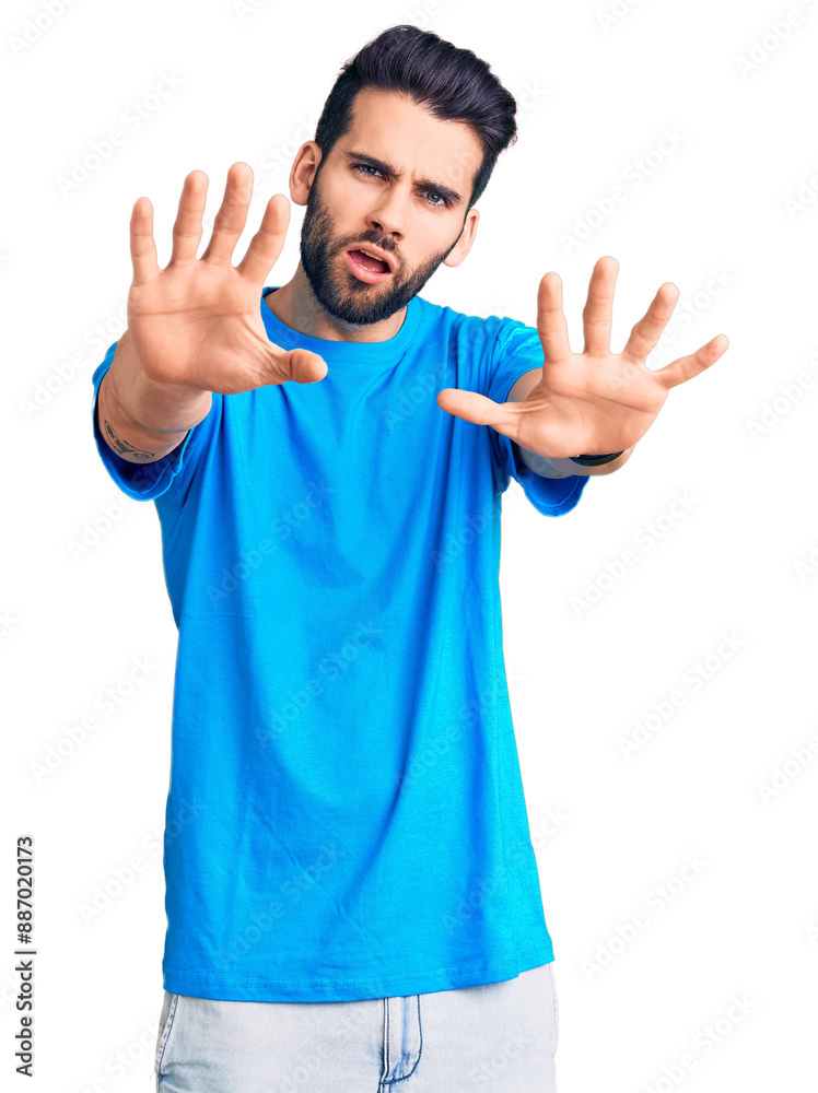 Young handsome man with beard wearing casual t-shirt doing stop gesture with hands palms, angry and frustration expression Young handsome man with beard wearing casual t-shirt doing stop gesture with hands palms, angry and frustration expression