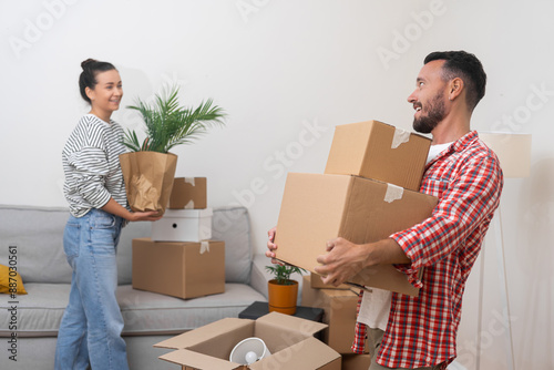 Young husband and wife collect parcels with things for moving living in new apartment in countryside collecting various home decorations in packing boxes