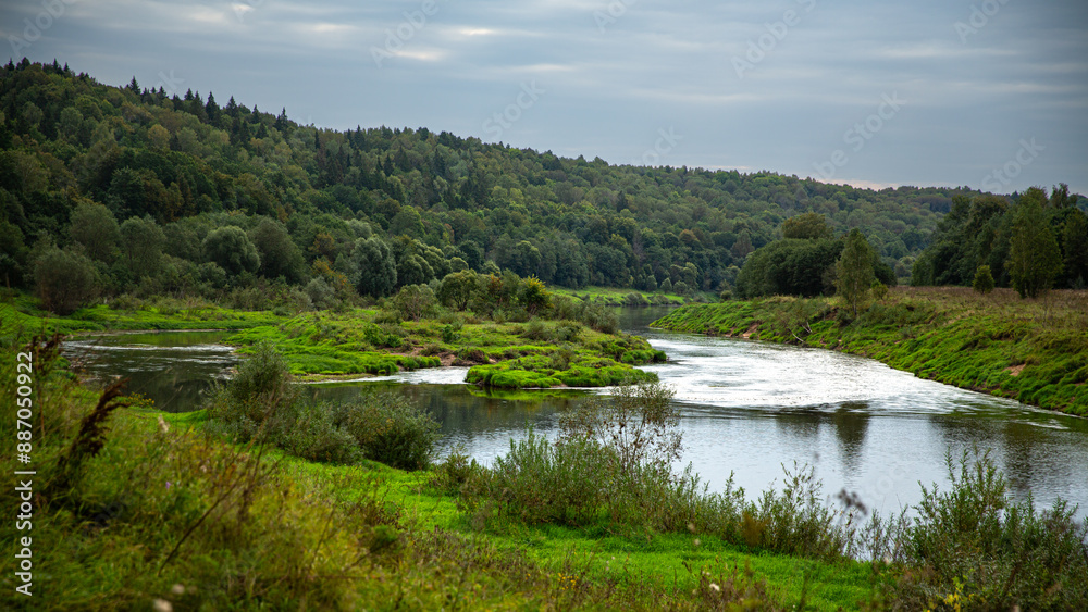 The river landscape is abundant with greenery and a forest, forming a tranquil and peaceful setting