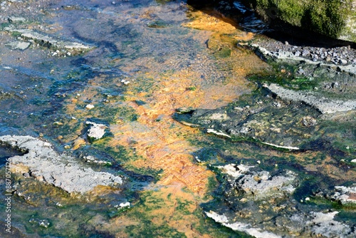 hot water flows from the crack in the colorful rock