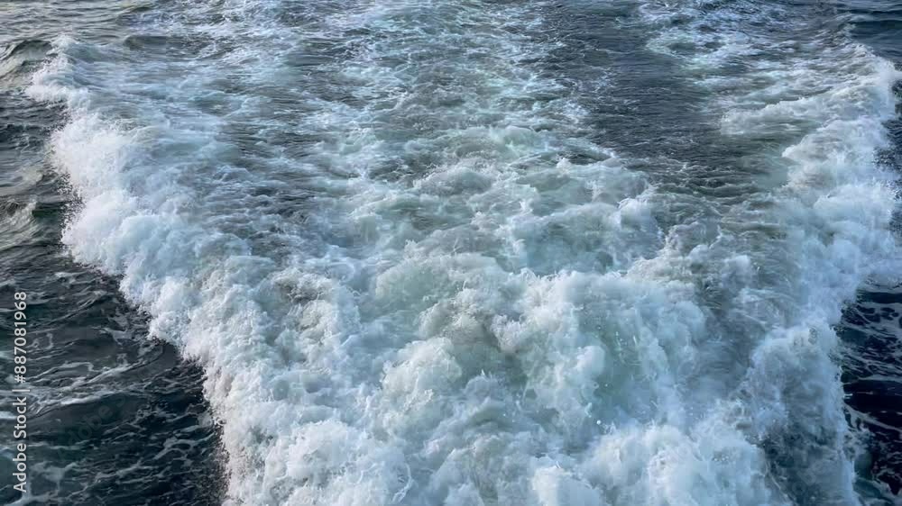 Big waves on water surface with white foam from moving ship in ocean Big waves on water surface with white foam from moving ship in ocean