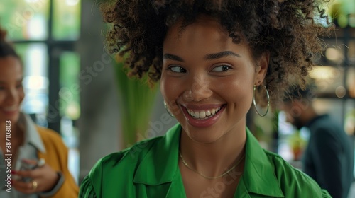 A young happy businesswoman in a refreshing green outfit meets with her colleagues in the office, showcasing teamwork and positivity