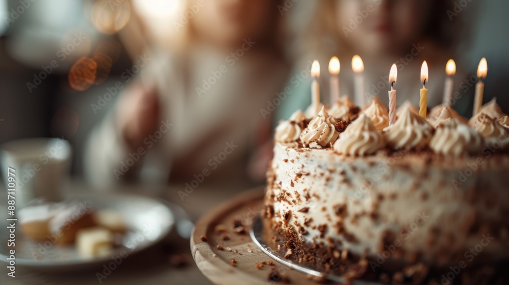Fototapeta premium A close-up of a beautifully decorated birthday cake with lit candles, surrounded by children. The image captures the joy and celebration of a special occasion.