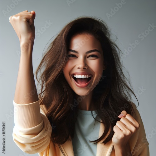 Jubilant Young Woman Celebrating a Victory With a Raised Fist in Studio