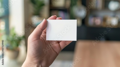 person holding a white card mockup in an office