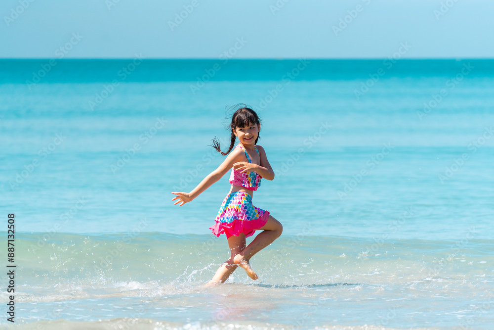 Happy children kid enjoy and fun outdoor lifestyle travel nature ocean on summer beach holiday vacation. Portrait of Little cute child girl in swimwear running and playing at the sea in sunny day. Happy children kid enjoy and fun outdoor lifestyle travel nature ocean on summer beach holiday vacation. Portrait of Little cute child girl in swimwear running and playing at the sea in sunny day.