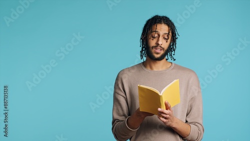 Foto Middle Eastern man reading book from publisher aloud, telling story, enjoying hobby