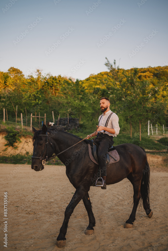 Full length of a cowboy horseback riding an equine at ranch in mountains Full length of a cowboy horseback riding an equine at ranch in mountains