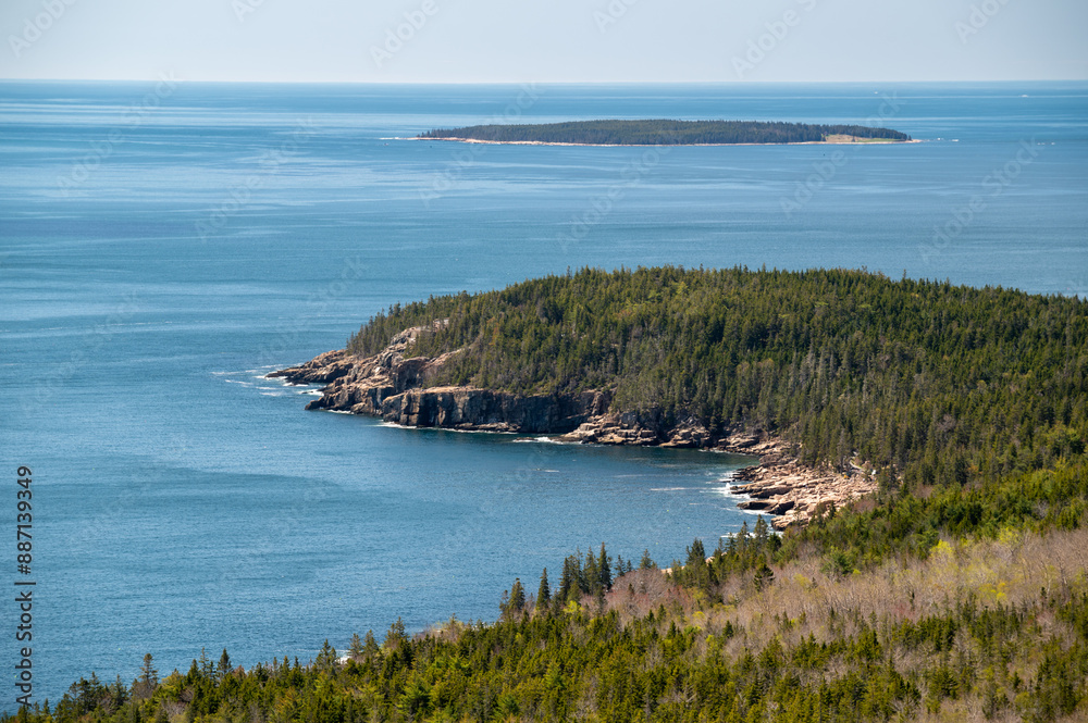 Coastal View of Acadia National Park in Spring. A panoramic view of the coastline of Acadia National Park in Maine. The blue ocean stretches out in the distance, with a small island visible in the ba Coastal View of Acadia National Park in Spring. A panoramic view of the coastline of Acadia National Park in Maine. The blue ocean stretches out in the distance, with a small island visible in the ba