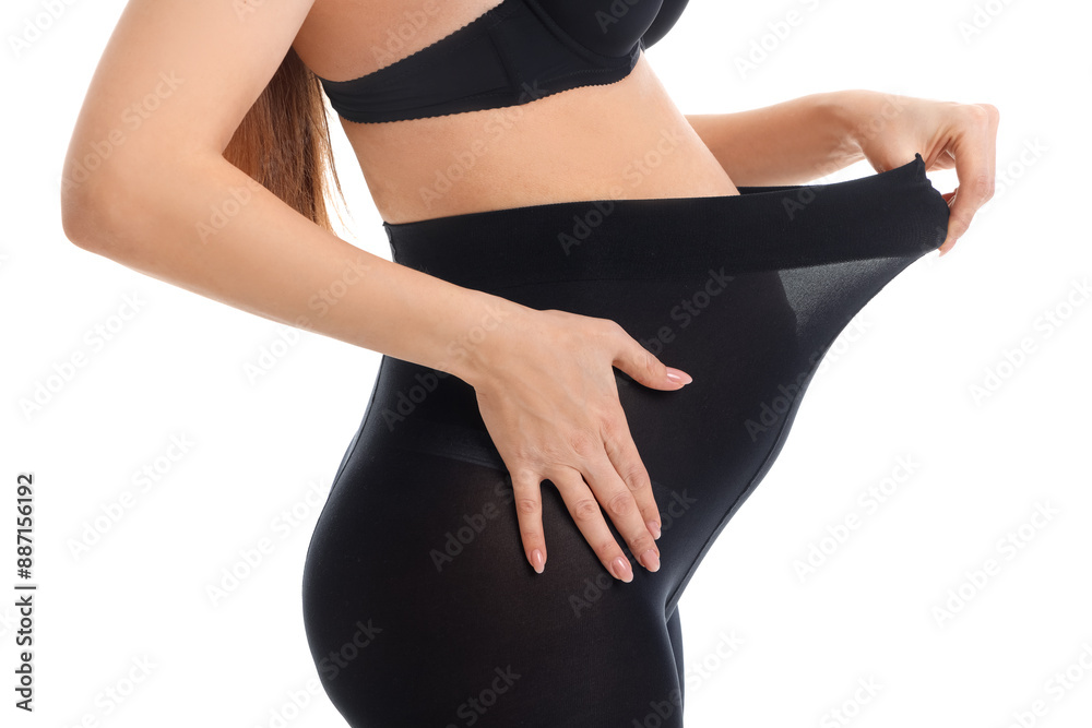 Fototapeta premium Young pregnant woman in black tights on white background, closeup
