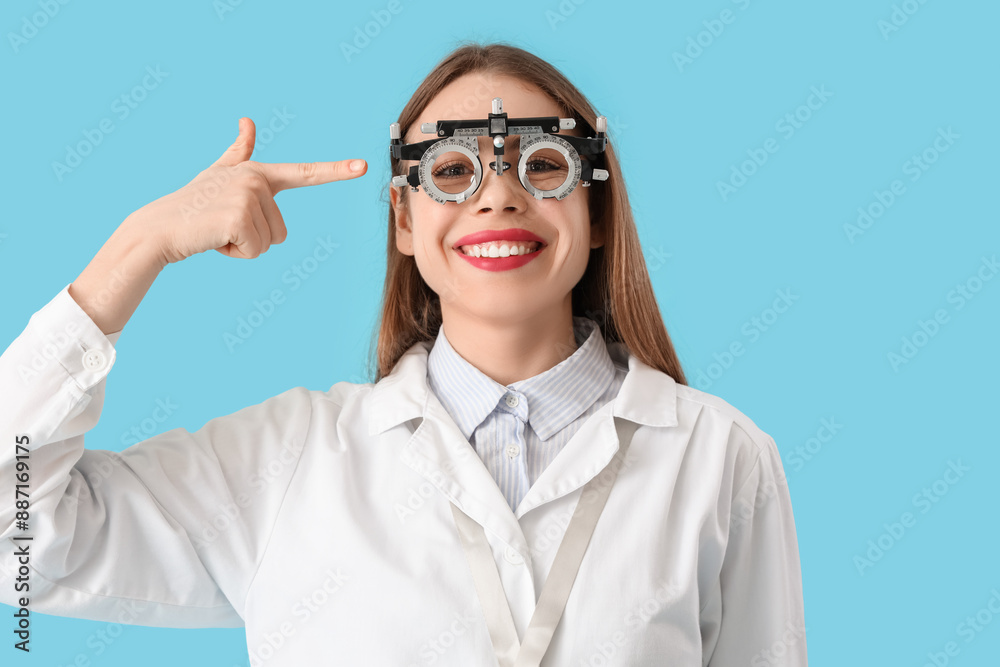 Female ophthalmologist pointing at trial frame on blue background Female ophthalmologist pointing at trial frame on blue background