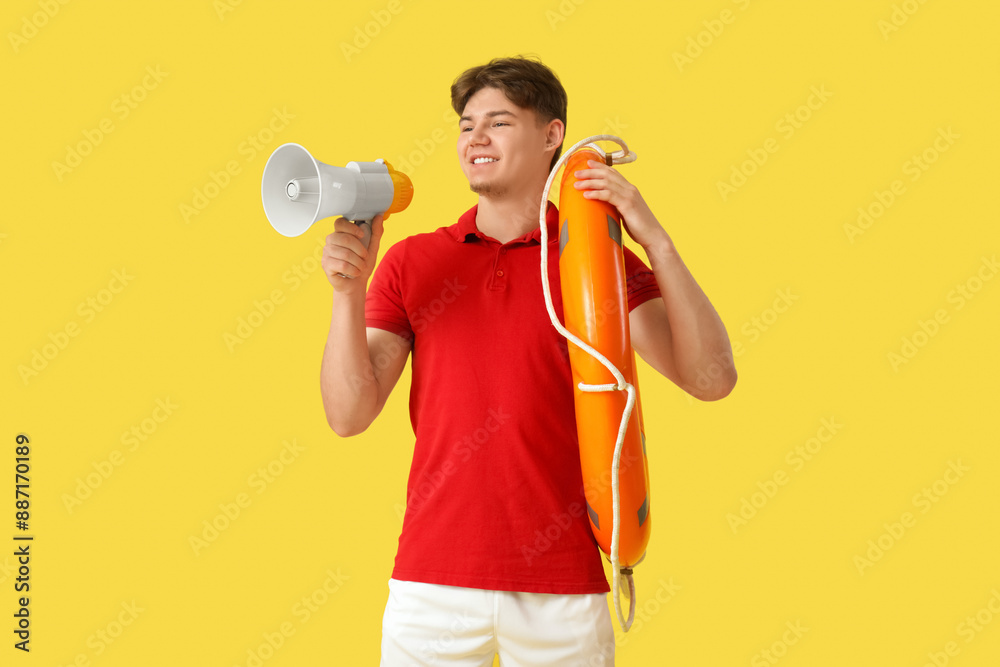 Male lifeguard with ring buoy and loudspeaker on yellow background Male lifeguard with ring buoy and loudspeaker on yellow background
