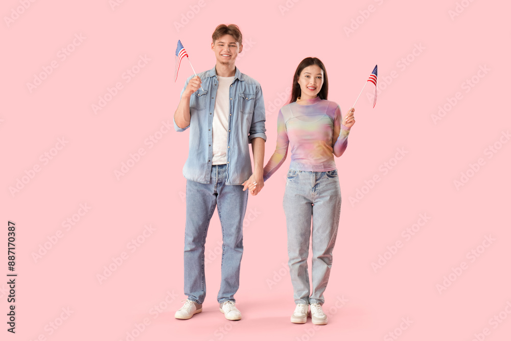 Young couple with flags of USA on pink background Young couple with flags of USA on pink background
