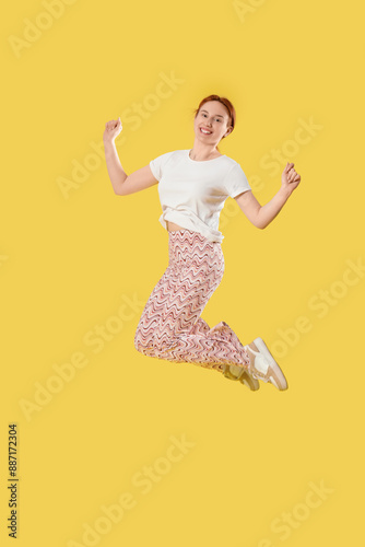 Young woman jumping on yell...