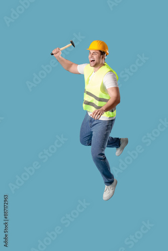 Young male builder jumping ...