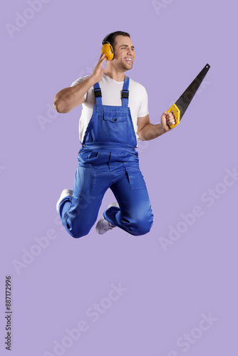 Young male builder with saw...