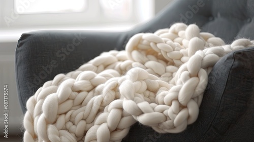 A blavk chair with a white bulk blanket Wool blanket knitted with hands photo