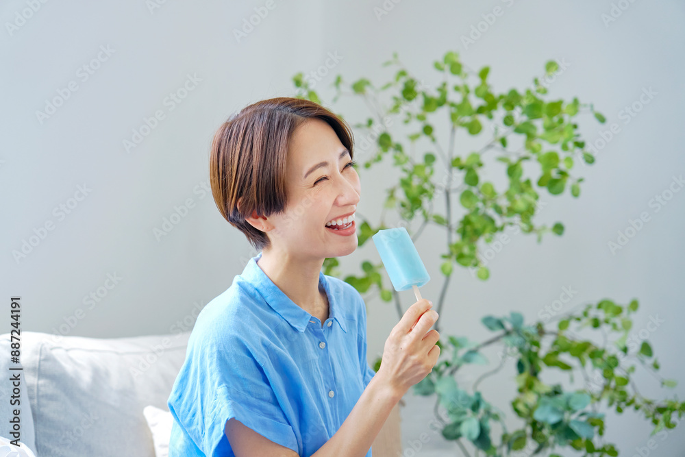 自宅で棒アイスを食べる女性