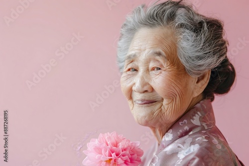 Elderly Asian woman with a peaceful smile holding  26 2 woman, senior, old, elderly, grandmother, smiling, face, mature, person, lady, people, smile, hair, aged, retirement, grandma, one, retired, gra photo