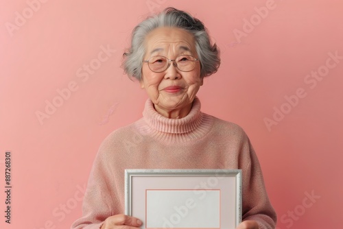 Elderly Asian woman with a thoughtful look holding 31 2 woman, senior, old, elderly, mature, people, person, computer, tablet, holding, lady, business, smile, grandmother, smiling, retired, older, gra photo