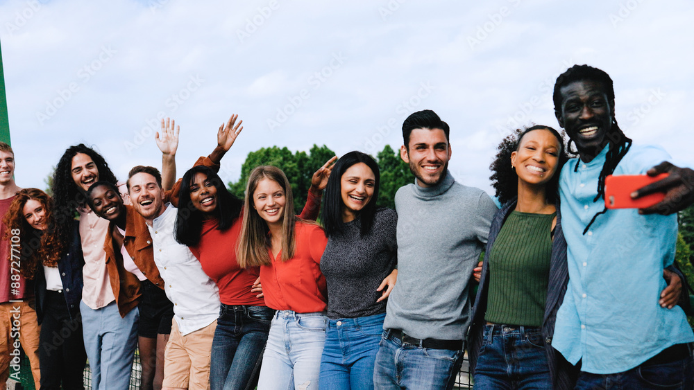 Diverse group of people taking selfie photo smiling at phone camera. Student team celebrating outside college campus. Summer vacation lifestyle Diverse group of people taking selfie photo smiling at phone camera. Student team celebrating outside college campus. Summer vacation lifestyle