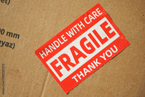 A cardboard box marked with a caution label for fragile goods handling during shipping