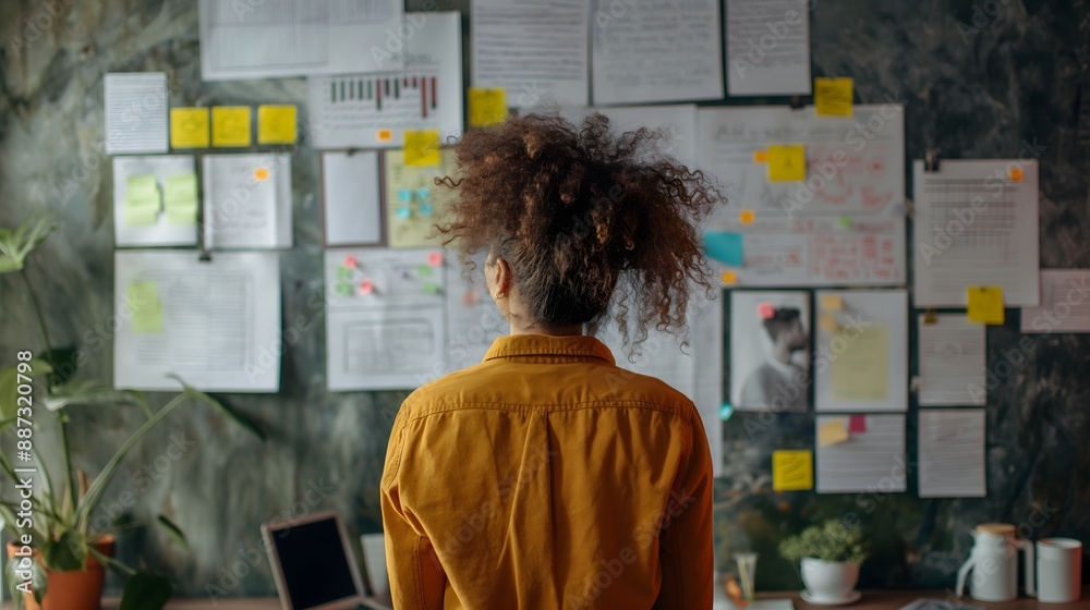 - An entrepreneur brainstorming and working on a new business idea in a creative workspace - An entrepreneur brainstorming and working on a new business idea in a creative workspace