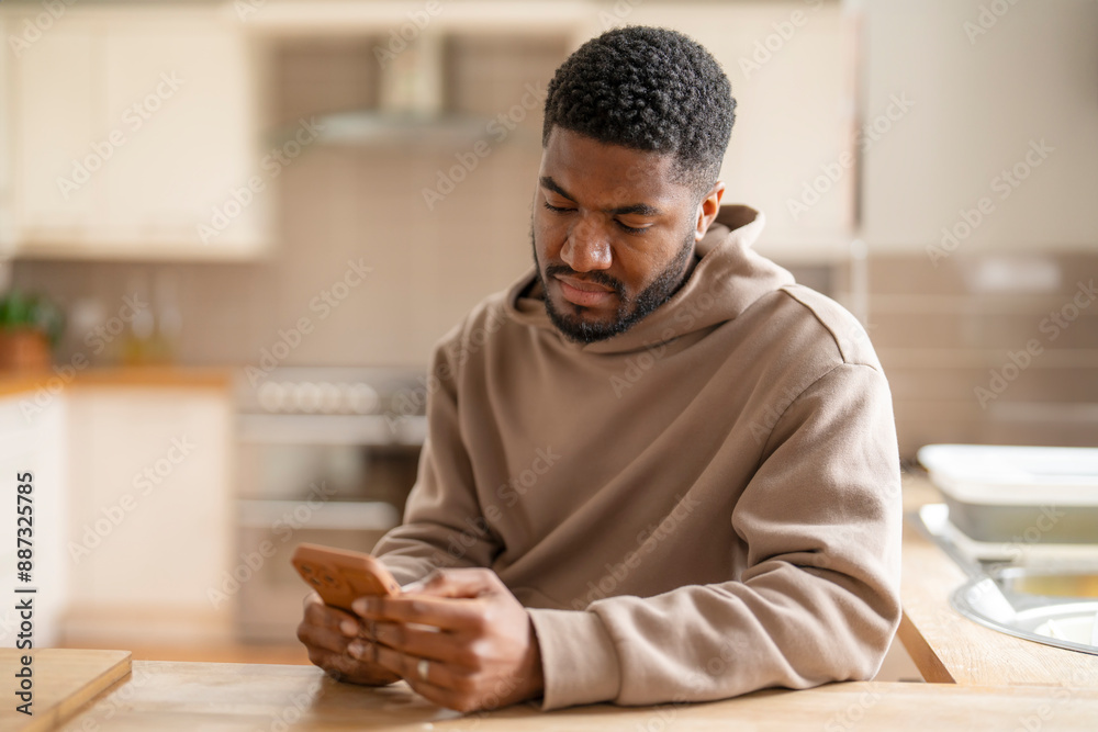 Man Using Smartphone In Modern Kitchen During Daytime