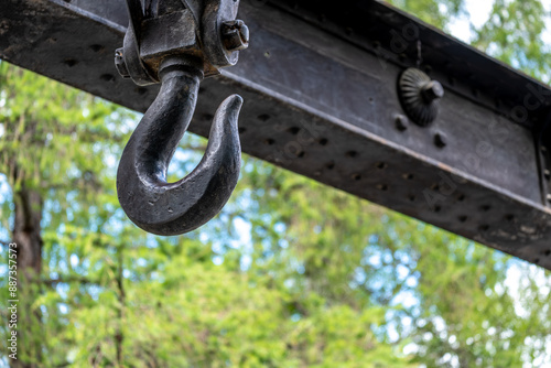 A massive steel hook on an iron beam.