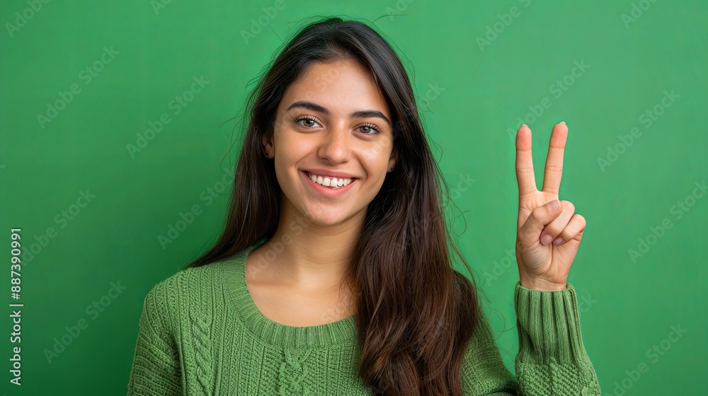 young woman, ok hand gesture, happy, standing against a green background young woman, ok hand gesture, happy, standing against a green background