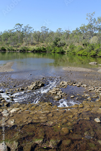 Serene natural scene of the Calliope River, trees and rocks at River Ranch in Queensland, Australia photo