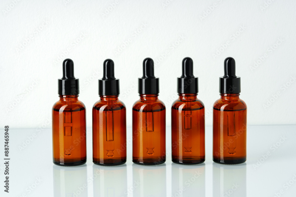 Row of various brown glass dropper bottles isolated on white background Row of various brown glass dropper bottles isolated on white background