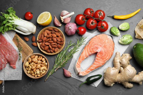 Flat lay composition with fresh fish and other products for balanced diet on black table