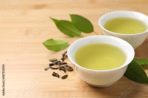 Wallpaper Mural Refreshing green tea in cups and leaves on wooden table, closeup. Space for text Torontodigital.ca